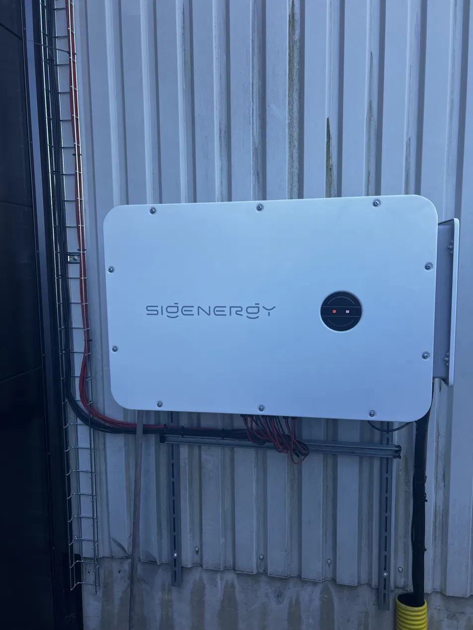 SigEnergy växelriktare monterad utomhus på en plåtfasad.